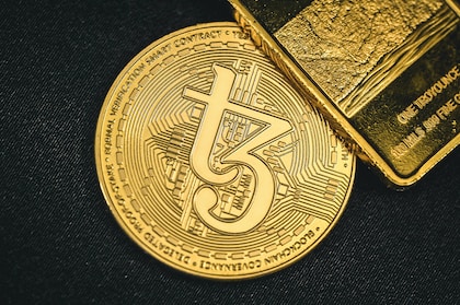 a close up of a gold coin on a black surface